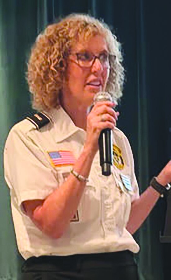 Volunteer Lt. Melissa Shoer speaking into a microphone at the presentation
