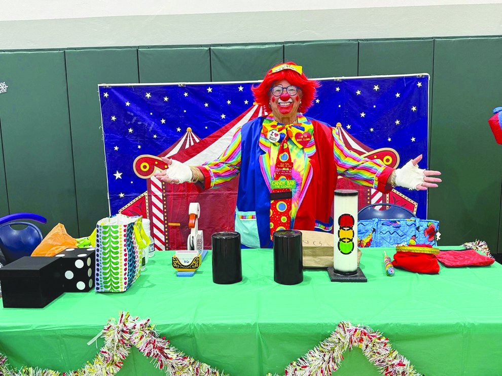 Clown instructor Candy Bar behind a table of magic props
