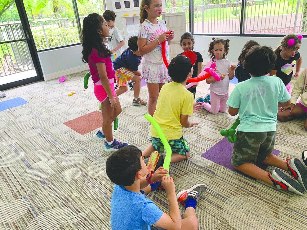Children twisting balloons into animals at a clown workshop