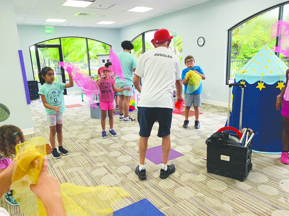 Instructor Juggles teaching children to juggle scarves