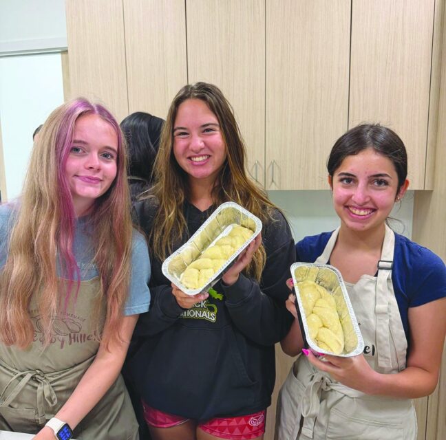 Sadie Bryant, Leah Forman and Isabel Gadilov holding fresh-baked challah