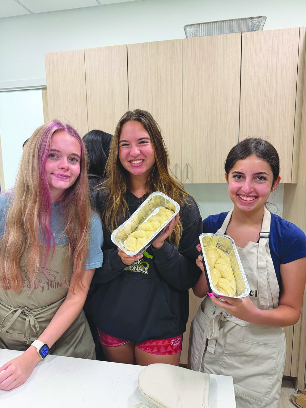Sadie Bryant, Leah Forman and Isabel Gadilov holding fresh-baked challah
